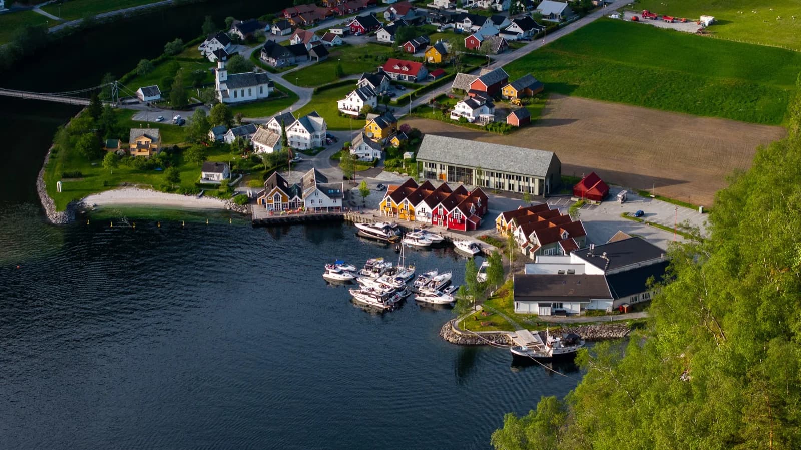 Dronefoto av Mo i Modalen: gjestehamna full av båtar ein sommarkveld
